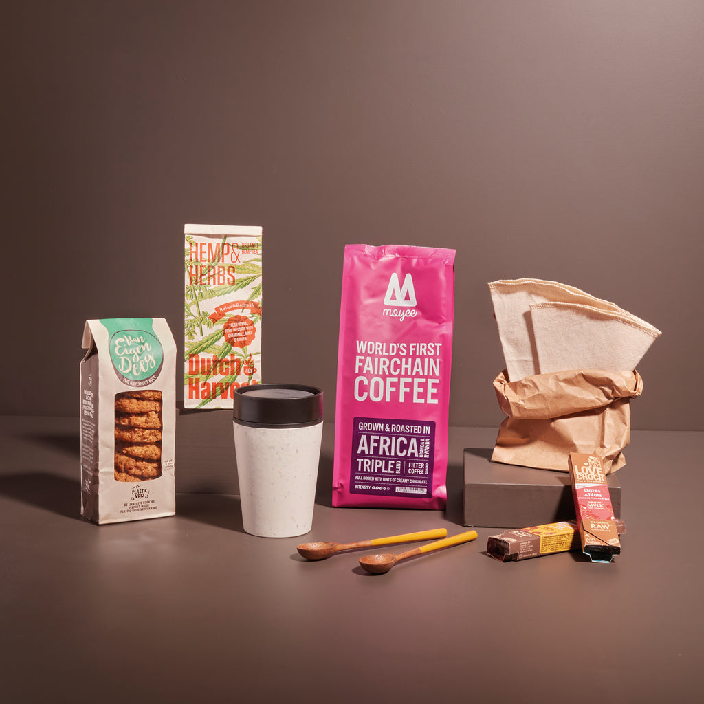 Duurzaam kerstpakket met ecologisch en sociaal geproduceerde producten. Koffiebeker, lepels, koffiefilters, koffie, chocolade en koekjes.